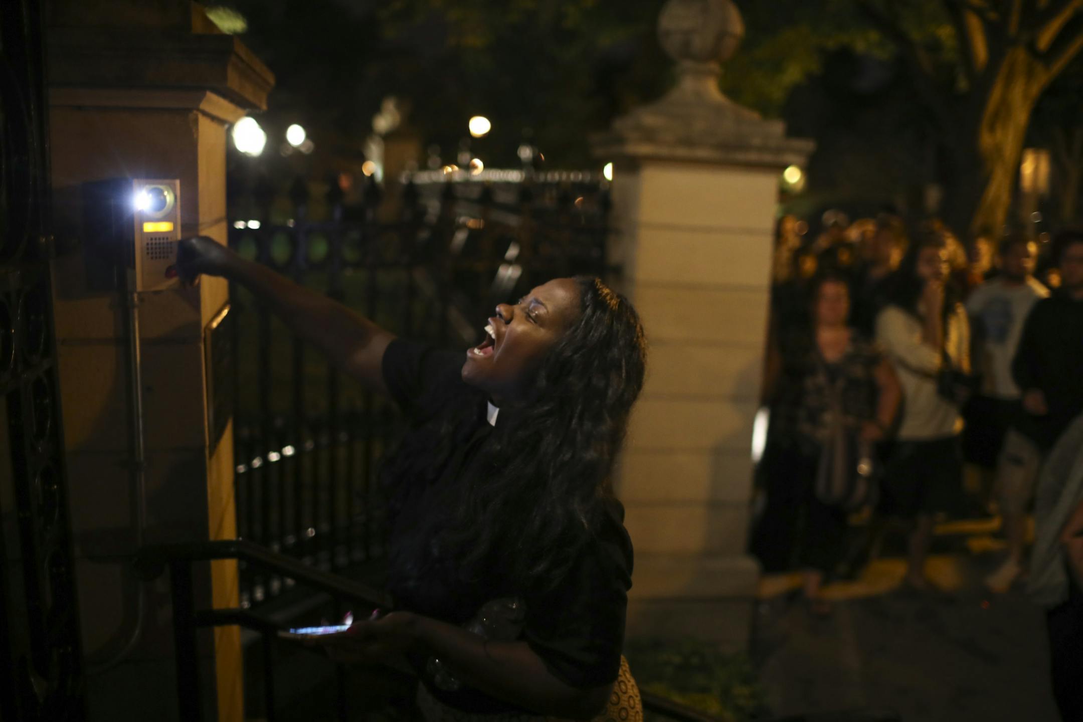 A woman rang the doorbell at the gate of the governor's residence as angry demonstrators chanted, honked horns and blocked Summit Avenue in St. Paul early Thursday, July 7, 2016.