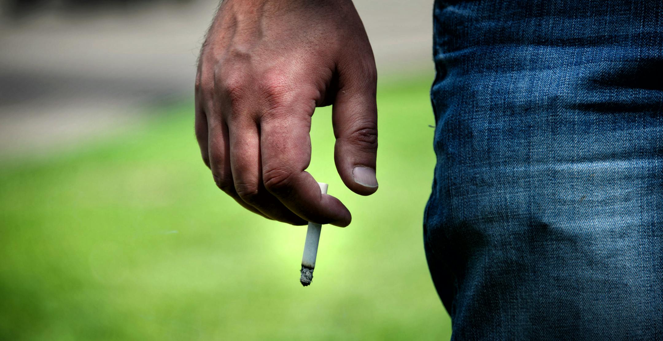 This man was smoking on the curb between Lake St. next to Lake Calhoun North Beach as a courtesy to other people at the park. Smoking is already not allowed at the beaches of Lake Calhoun Park. The Minneapolis Park Board Recreation Committee is proposing to ban smoking in all city parks. Wednesday, June 4, 2014 ] GLEN STUBBE * gstubbe@startribune.com