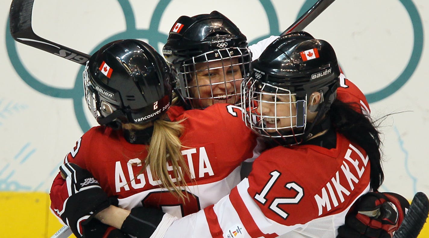 BRIAN PETERSON &#x2022; brianp@startribune.com Vancouver, BC - 02/25/2010 - Women's Gold Medal Hockey Game at Canada Hockey Place - USA vs Canada ] Canada's Marie-Philip Poulin (center) celebrates with teammates after she shot the puck past USA's goalie Jessie Vetter twice in the first period. This was the second goal by Poulin. ORG XMIT: MIN2013032117295615