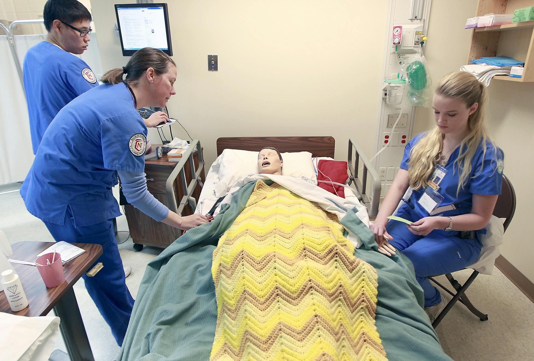 Normandale Community College nursing students from left, Injung Kim, Pamela Peterson, and Rebecca Rud, worked on a lifelike, high-tech mannequin during class on hospice care, Thursday, April 23, 2015 in Bloomington, MN. ] (ELIZABETH FLORES/STAR TRIBUNE) ELIZABETH FLORES • eflores@startribune.com