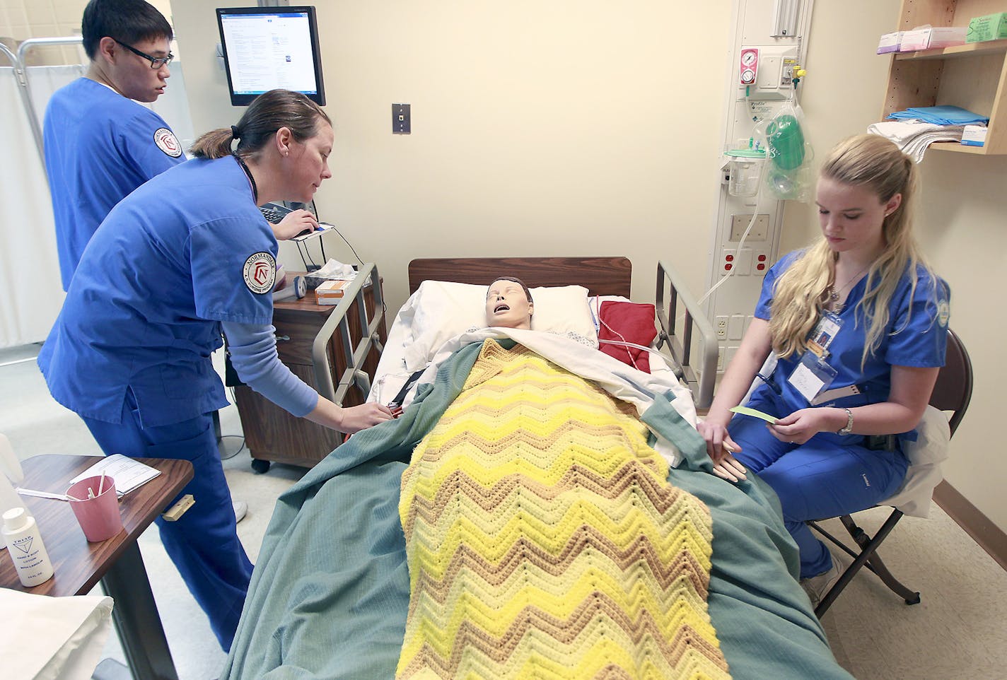 Normandale Community College nursing students from left, Injung Kim, Pamela Peterson, and Rebecca Rud, worked on a lifelike, high-tech mannequin during class on hospice care, Thursday, April 23, 2015 in Bloomington, MN. ] (ELIZABETH FLORES/STAR TRIBUNE) ELIZABETH FLORES &#x2022; eflores@startribune.com