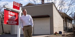 Realtor Jonathan Sells posed for a portrait next to a SOLD sign ouside a home he recently sold in Minneapolis on Monday.