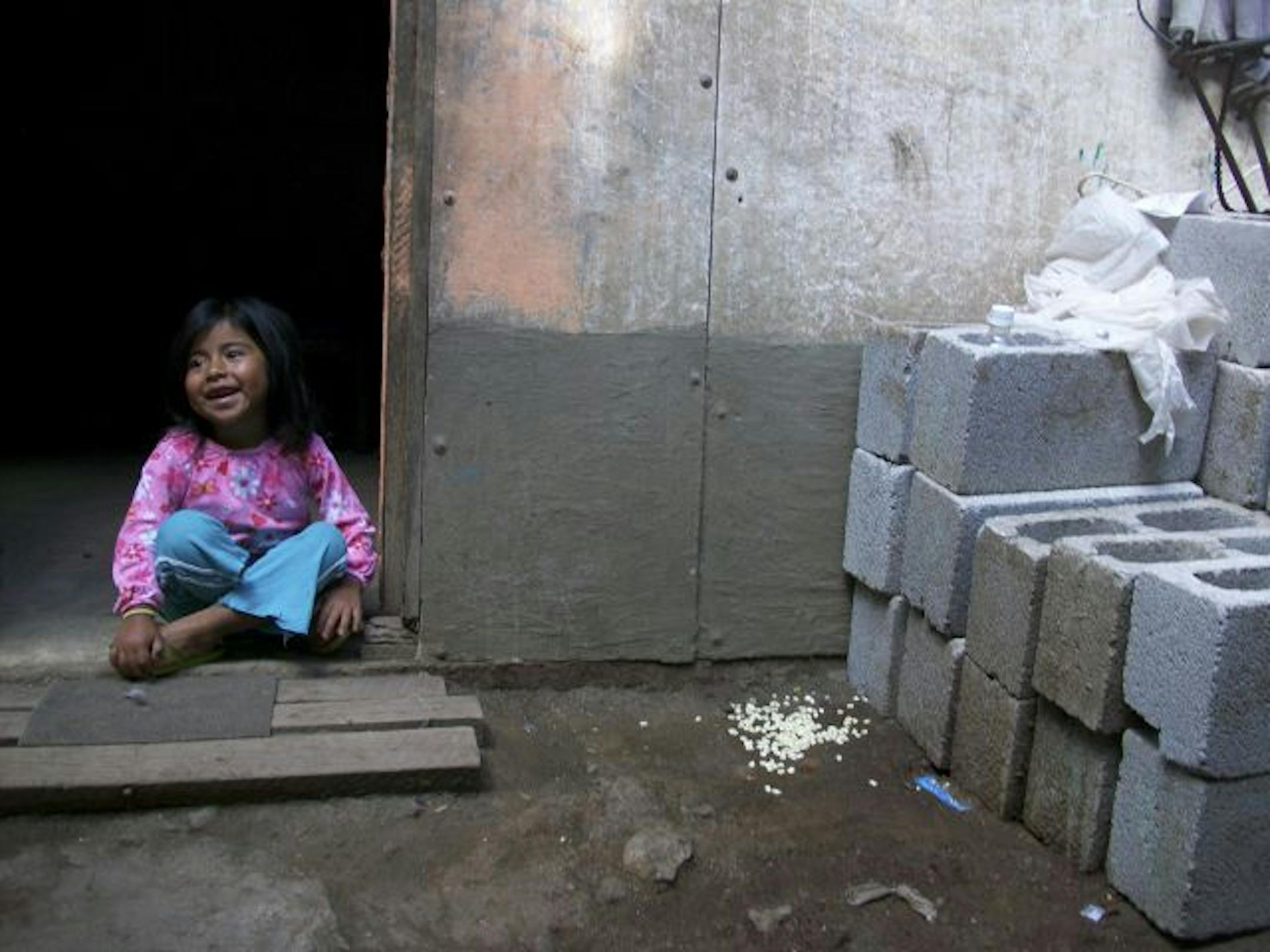 A girl happily watched volunteers build a house for her family in the Antigua Valley.