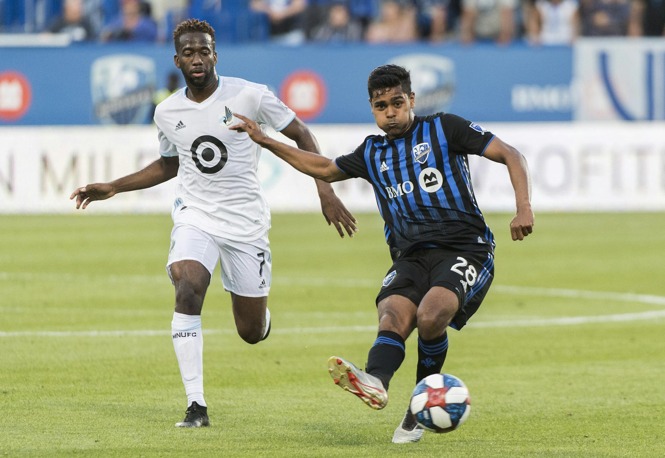 Montreal Impact's Shamit Shome, right, plays a pass as Minnesota United's Kevin Molino moves in during first half of an MLS soccer match in Montreal, Saturday, July 6, 2019. (Graham Hughes/The Canadian Press via AP)