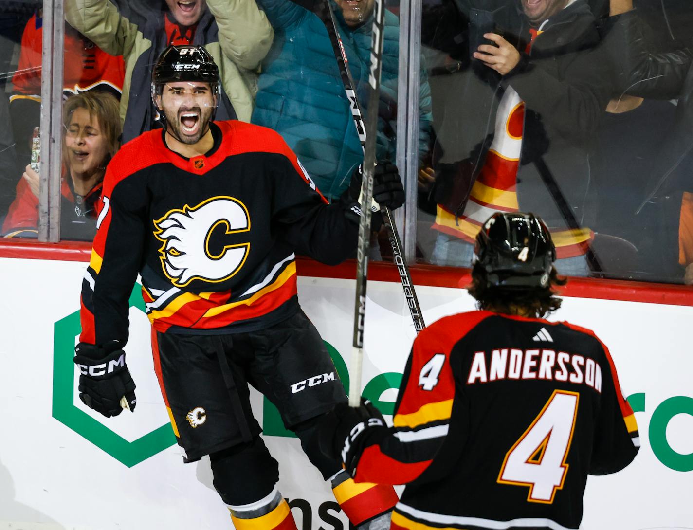 Calgary Flames forward Nazem Kadri, left, celebrates his goal with teammate Rasmus Andersson during the third period of an NHL hockey game against the Arizona Coyotes in Calgary, Alberta, Monday, Dec. 5, 2022. (Jeff McIntosh/The Canadian Press via AP)