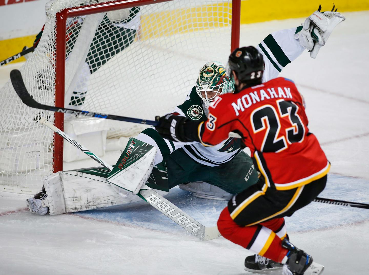 Minnesota Wild goalie Devan Dubnyk gives up a goal to Calgary Flames center Sean Monahan (23) during the first period of an NHL hockey game Wednesday, Feb. 1, 2017, in Calgary, Alberta. (Jeff McIntosh/The Canadian Press via AP)