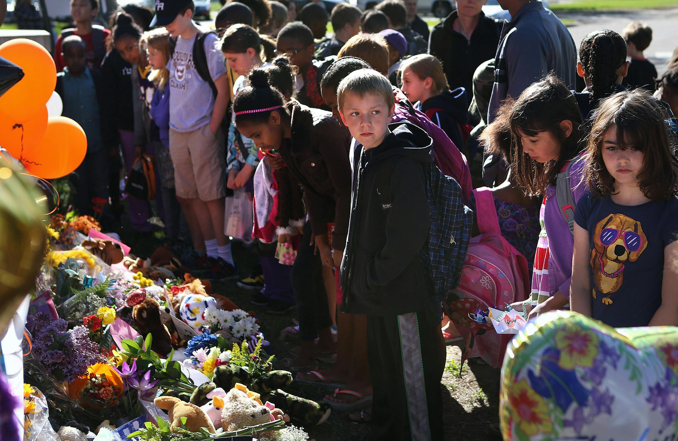 Students stopped to place mementos and reflect at a makeshift memorial outside Peter Hobart Elementary School in St. Louis Park on Friday, May 24, 2013.