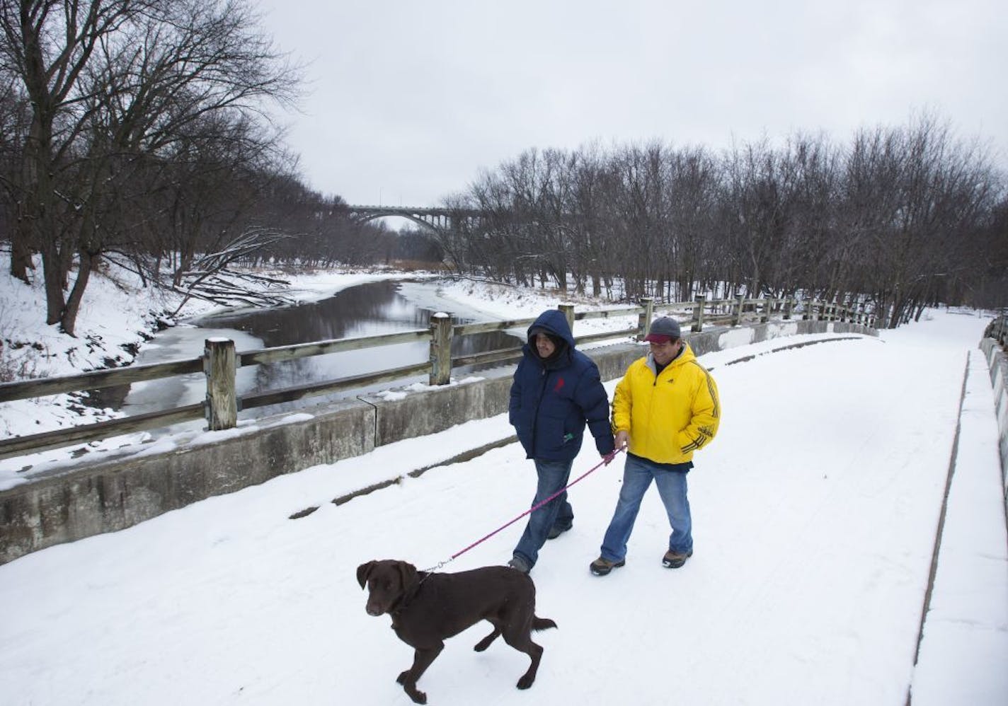 Ivan Torres and his father Tony Torres, right, walked their dog Sasha on a bridge that crosses to Pike Island at Fort Snelling State Park on Friday, January 8, 2015, in St. Paul , Minn.