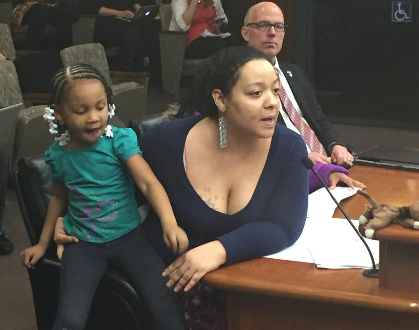 Roxxanne O'Brien of north Minneapolis testifies in opposition to a bill proposing the reopening of a private prison in Appleton, Minn. Behind her is Rep. Tim Miller, the author of the bill to reopen the prison.