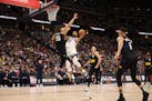 Rudy Gobert of the Timberwolves was guarded by an airborne Aaron Gordon of the Nuggets on Tuesday night at Ball Arena in Denver.
