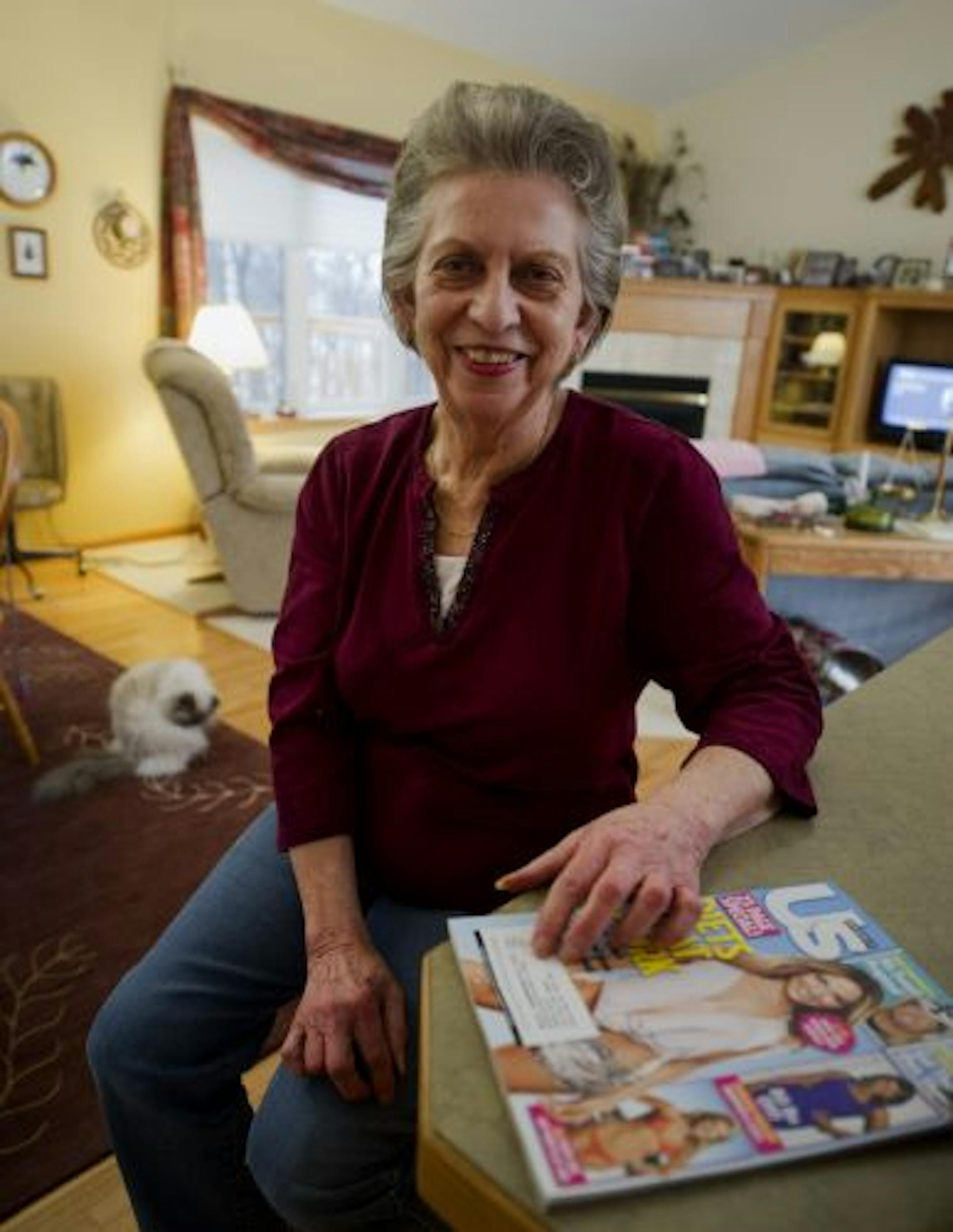 Janice Miller paid $80 to a third party for a four-year subscription to Reader's Digest, but instead she receives celebrity gossip magazines, Photo and Self. Her cat Lola is in background.