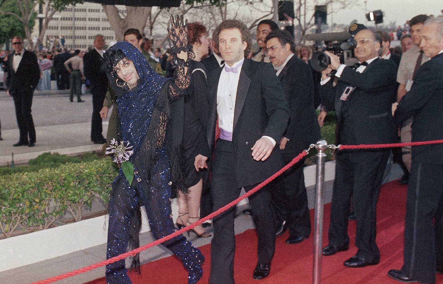 Rock singer Prince waves to the crowd upon his arrival outside the Dorothy Chandler Pavilion, site of the 57th Academy Awards, March 25, 1985 in Los Angeles. The singer won an Oscar for original score. (AP Photo/Doug Pizac)