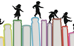 iStockphoto.com Children silhouette on top of upright books.