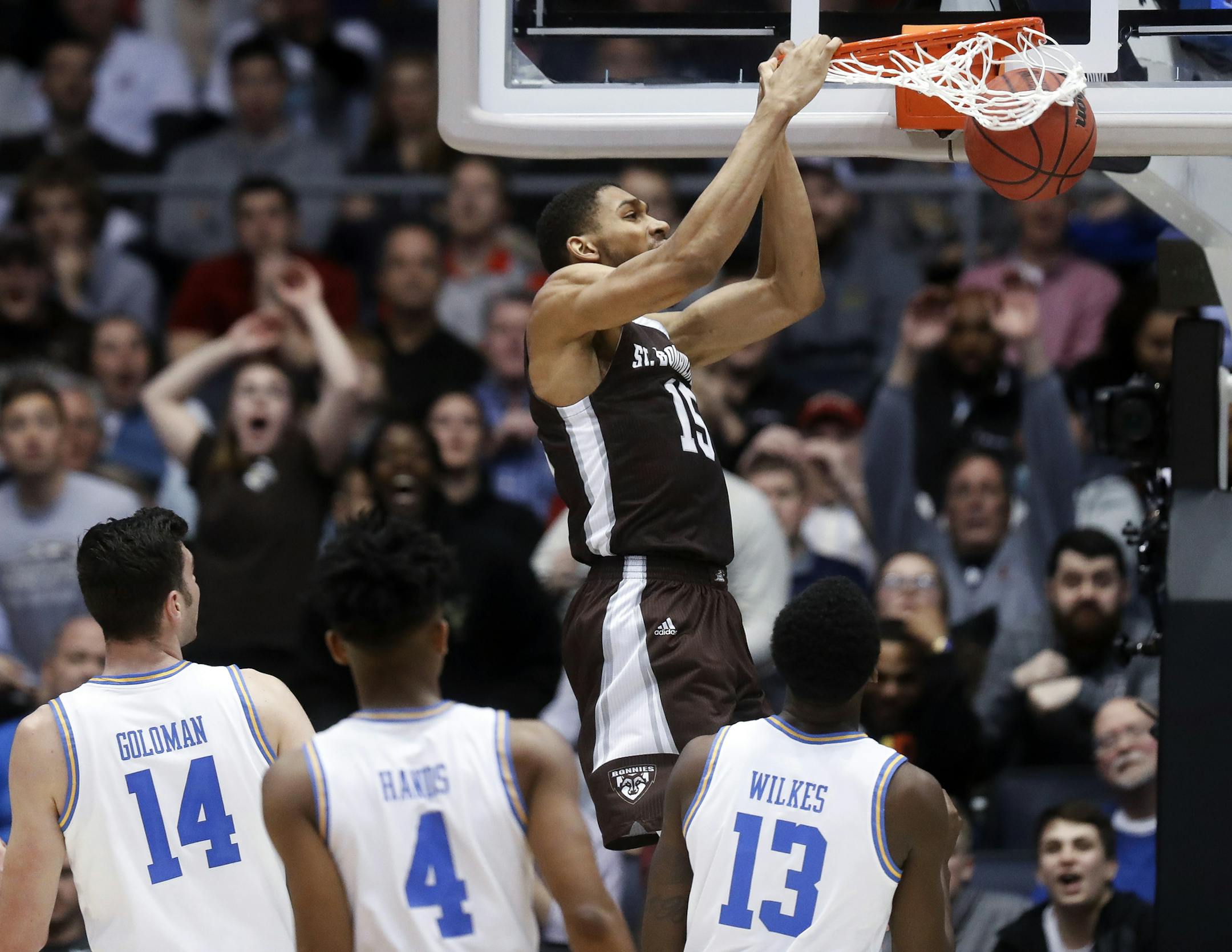St. Bonaventure's LaDarien Griffin (15) dunks as UCLA's Kris Wilkes (13) looks on during the first half of a First Four game of the NCAA men's college basketball tournament, Tuesday, March 13, 2018, in Dayton, Ohio. (AP Photo/John Minchillo)