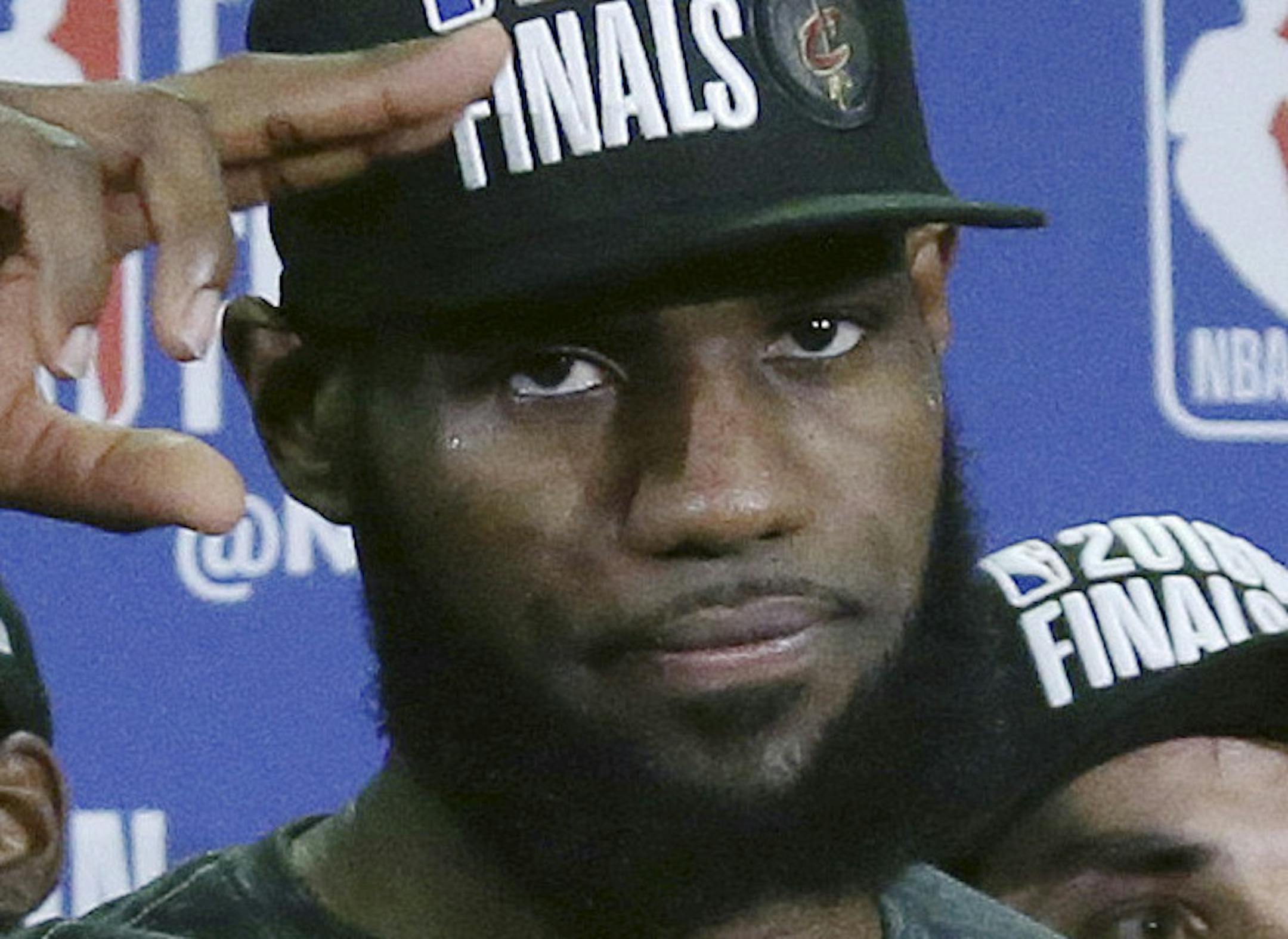 Cleveland Cavaliers forward LeBron James salutes after his team was presented the trophy for beating the Boston Celtics 87-79 in Game 7 of the NBA basketball Eastern Conference finals, Sunday, May 27, 2018, in Boston. (AP Photo/Elise Amendola)