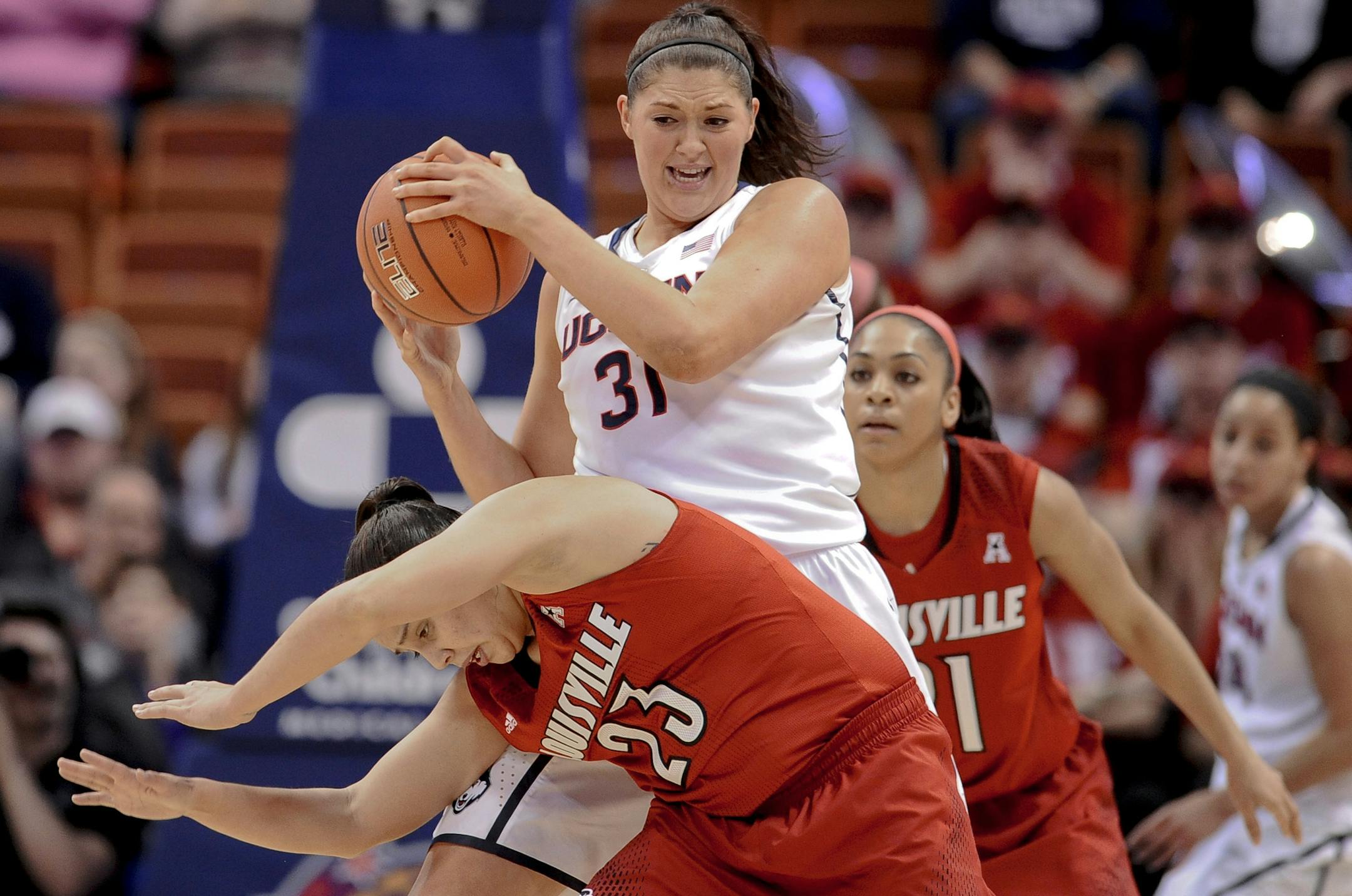 Connecticut's Stefanie Dolson, top, keeps the ball from Louisville's Shoni Schimmel, bottom, during the first half of an NCAA women's college basketball game in the finals of the American Athletic Conference basketball tournament, Monday, March 10, 2014, in Uncasville, Conn. (AP Photo/Jessica Hill)