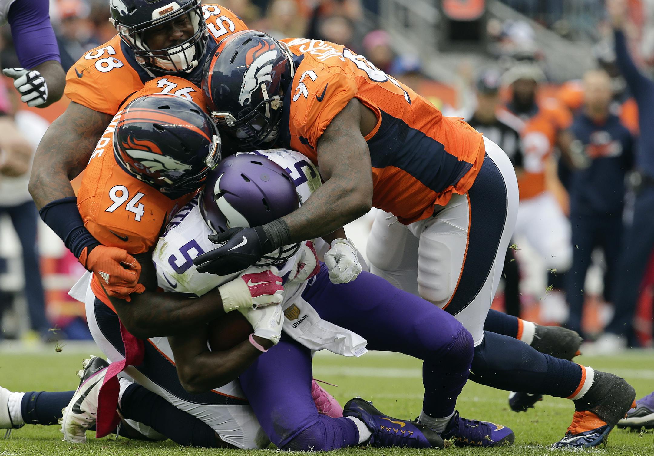Minnesota Vikings quarterback Teddy Bridgewater (5) is sacked by Denver Broncos outside linebacker Von Miller (58) outside linebacker DeMarcus Ware (94) and defensive end Malik Jackson (97) during the first half of an NFL football game Sunday, Oct. 4, 2015, in Denver. (AP Photo/Joe Mahoney)