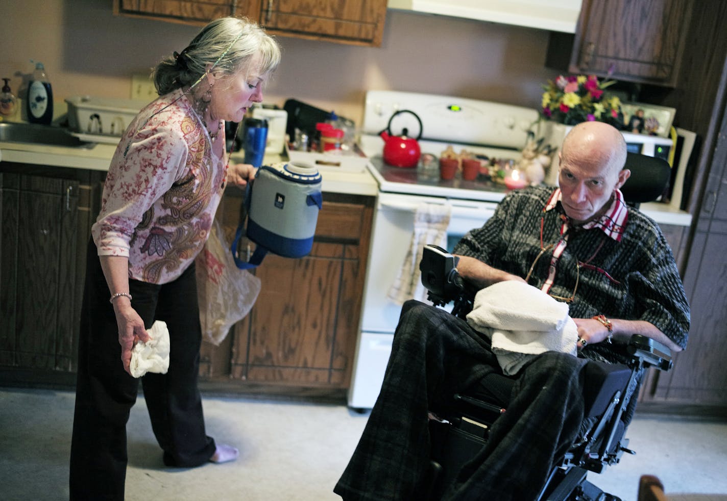 Because a Crystal care PCA did not show up, Joyce Parsons tried to move her husband Jerry,]from his bed to a wheelchair but dropped him. He lay motionless on the floor with a sharp shooting pain through his lower back.] Here she is helping clean up a dropped catheter container spillage.richard.tsong-taatarii/rtsong-taatarii@startribune.com