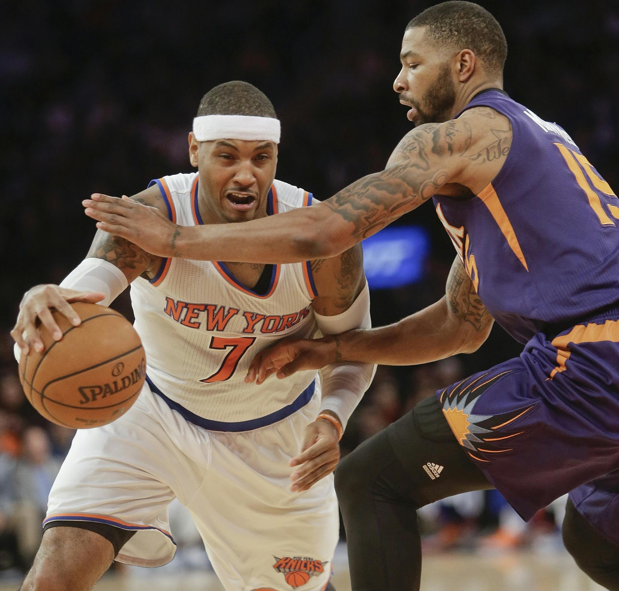 New York Knicks' Carmelo Anthony (7) drives past Phoenix Suns' Marcus Morris (15) during the second half of an NBA basketball game, Saturday, Dec. 20, 2014, in New York. The Suns won the game 99-90. (AP Photo/Frank Franklin II)
