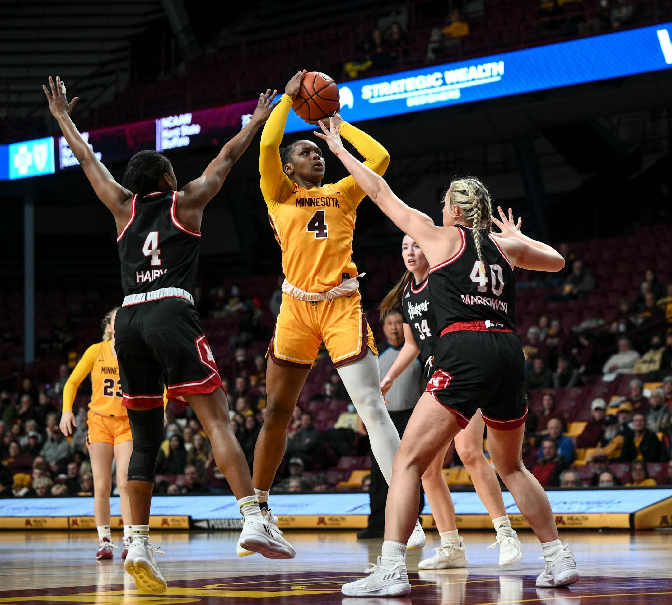 Minnesota forward Alanna Micheaux (4) scores 2-points on a jump shot as she's defended by Nebraska center Alexis Markowski (40) and guard Sam Haiby (4) during the first half.