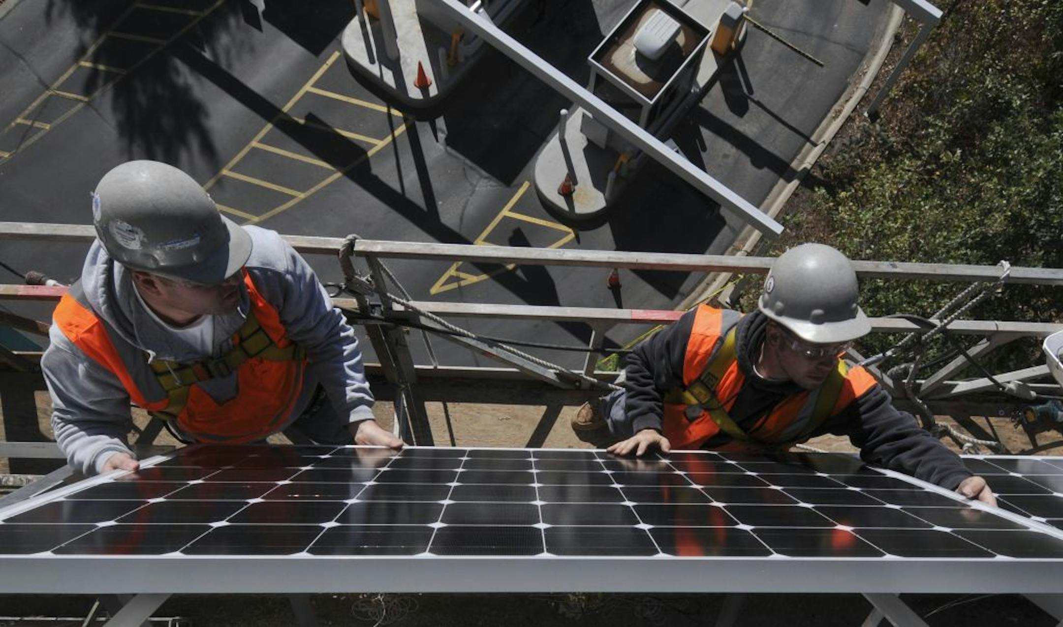 Workers installed solar panels on the side of the Saint Paul RiverCentre Parking Ramp
