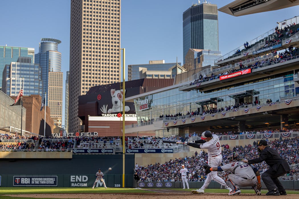 Minnesota Twins left fielder Trevor Larnach gets a hit at bat with the downtown Minneapolis skyline as a back drop on opening day at Target Field in 2023.