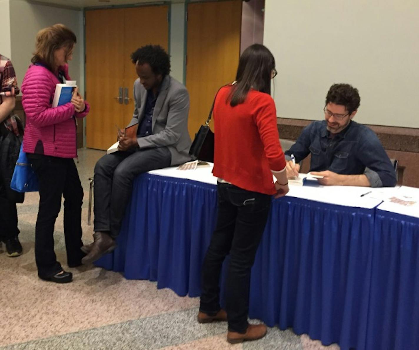 Writers Dinaw Mengestu and Joshua Ferris autograph books after their Saturday night keynote event.