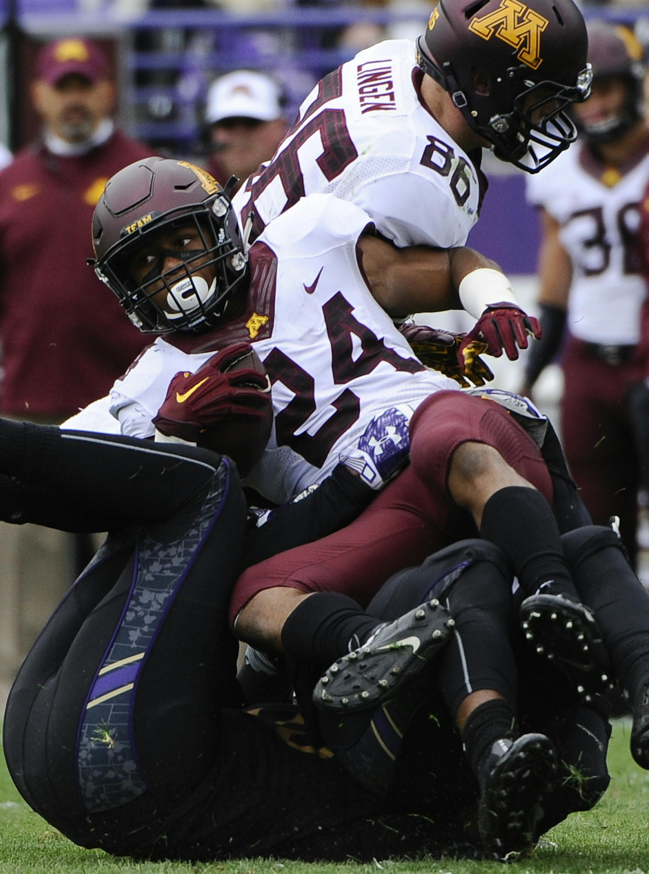 Northwestern linebacker Anthony Walker (18) and Northwestern Wildcats linebacker Drew Smith (55) tackle Minnesota running back Rodney Smith (24) during the second of an NCAA college football game in Evanston, Ill., Saturday, Oct. 3, 2015. (AP Photo/Matt Marton)