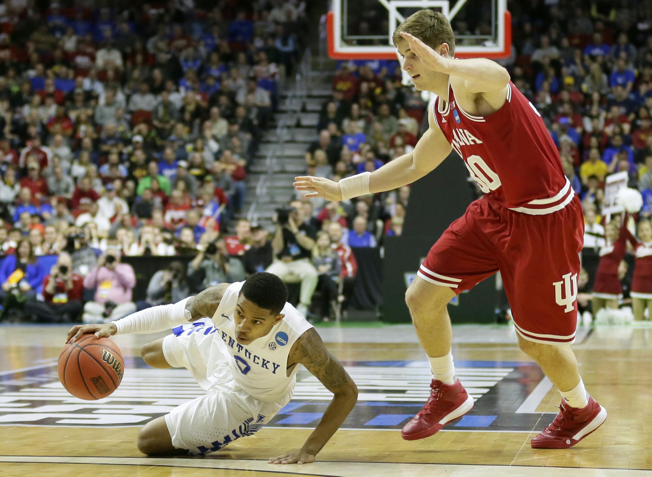 Kentucky guard Tyler Ulis, left, falls to the floor in front of Indiana forward Collin Hartman during the second half of a second-round men's college basketball game in the NCAA Tournament, Saturday, March 19, 2016, in Des Moines, Iowa. (AP Photo/Charlie Neibergall)