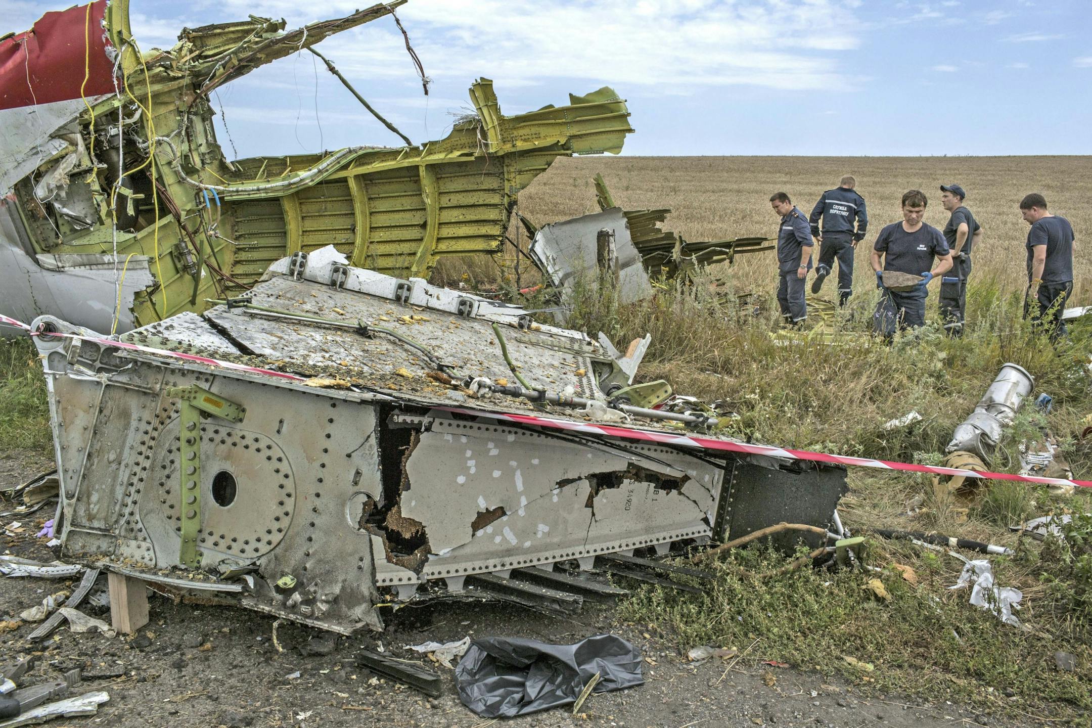 Rescue service members work around aircraft parts at the site of the Malaysia jet crash near Grabovo, Ukraine, July 20, 2014.