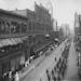 A parade on 4th Street passing by the Grand Arcade in 1907. The towered building to the rear is the old St. Paul City Hall-Ramsey County Courthouse, r
