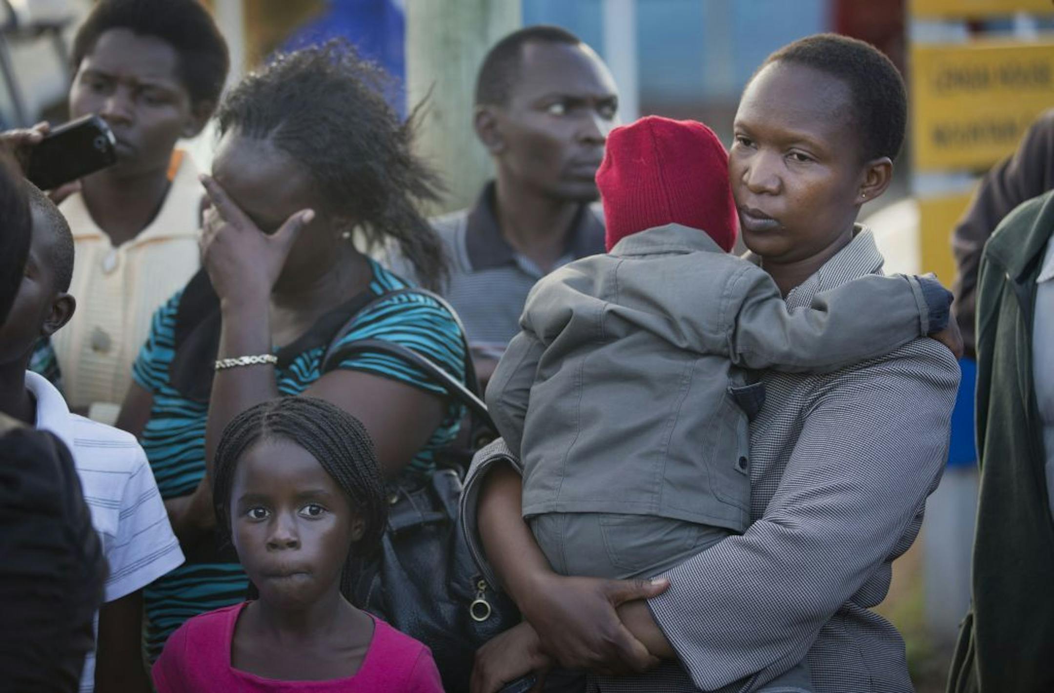 Relative Ziporah Mora, right, holds her child whom she declined to name, as she waits for news of the return of the bodies of those killed in the Mandera attack, with other relatives at Wilson Airport in Nairobi, Kenya Saturday, Nov. 22, 2014. Somalia's Islamic extremist rebels, al-Shabab, claimed responsibility for the Saturday dawn attack on a bus in the northern Kenyan town of Mandera, near the Somali border, in which 28 non-Muslims were singled out and killed.