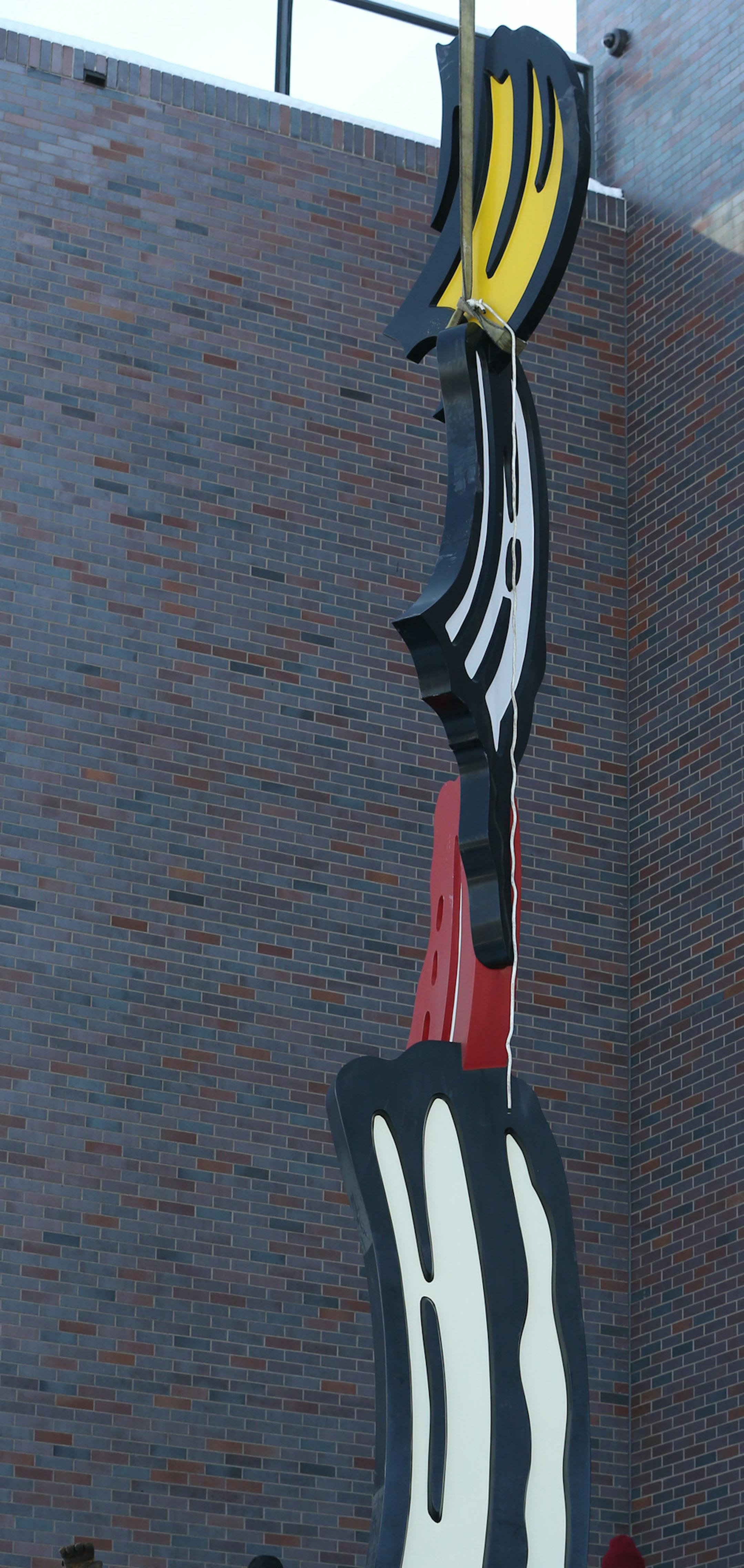 Crews from the Walker Art Center and Rocket Crane re-install Roy Lichtenstein's Salute to Painting on the Vineland Terrace on 12/12/13. The sculpture is a big colorful brush stroke by the late Roy Lichtenstein, which was given to the Walker back in the 1990s by former board members in honor of then director Martin Friedman. The sculpture has been in storage for past year while the 1971 wing of the building, designed by architect Edward Larrabee Barnes, was re-bricked. The $8 million re-bricking