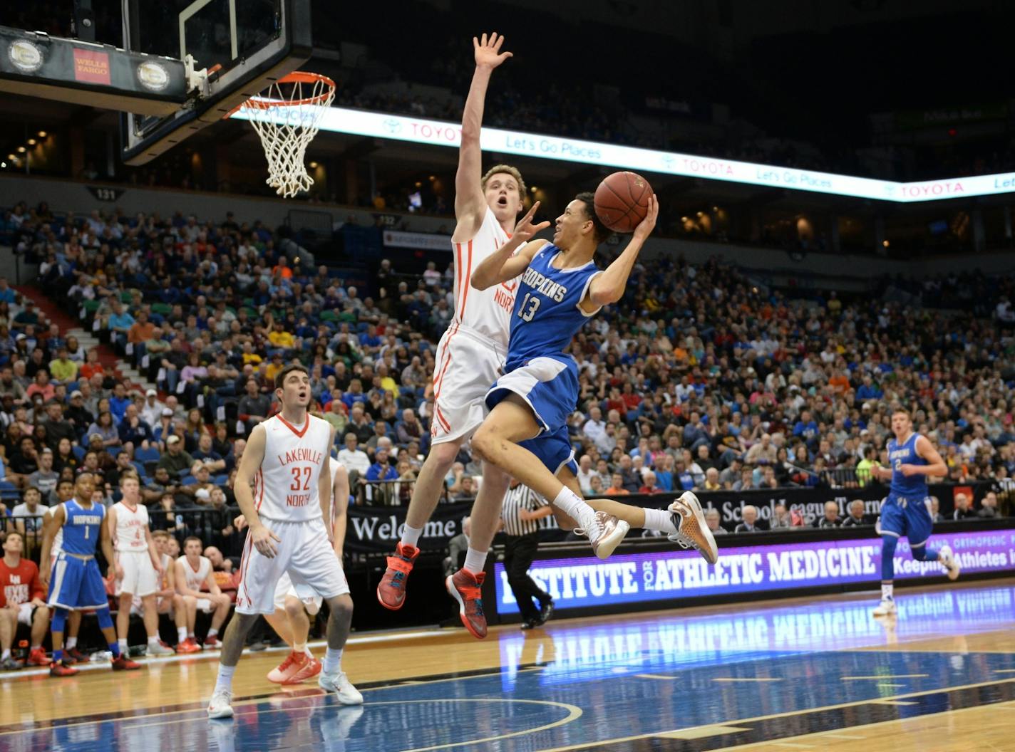 Hopkins guard Amir Coffey (13), named Mr. Basketball on Monday, scored off a layup while being guarded by Lakeville North guard Carter Brooks (22) in the first half of the Class 4A championship game on Saturday.