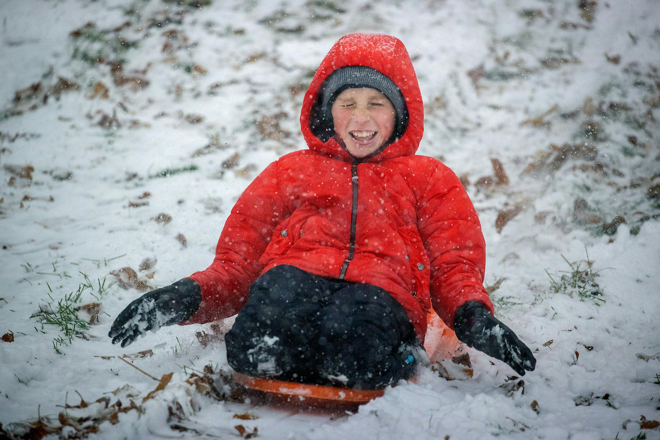 Fritz Saunders, 11, made his way down a hill on a sled in the fresh fallen snow near Lake Nokomis in Minneapolis. ] ELIZABETH FLORES • liz.flores@startribune.com