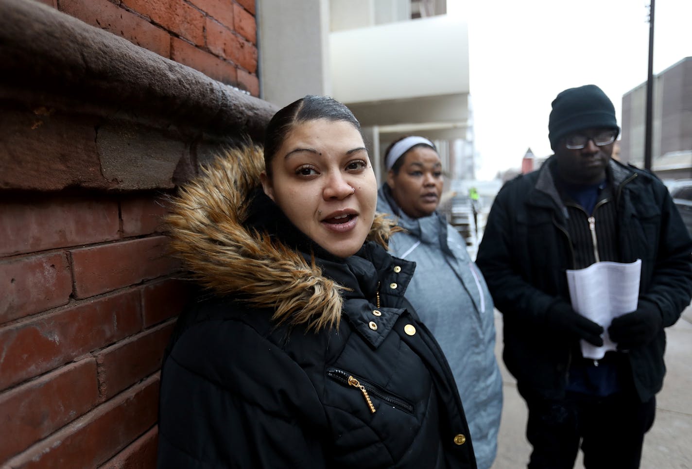 Minneapolis residents displaced by the Christmas Day at the Francis Drake Hotel apartment stand outside a temporary shelter set up at the First Covenant Church Minneapolis Thursday, Jan. 2, 2020, in Minneapolis, MN. Discussing their fate is Domonique Howell, left to right, Tavonne Moses, and Damian Ashcraft . All three work and paid to live at the Drake but feel as though information is being withheld from them as well as donated funding that could get them back in a home. "We just want our live