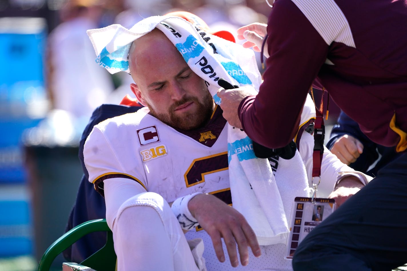 Minnesota quarterback Tanner Morgan has a towel placed over his head as he is transported to the locker room after being injured during a NCAA college football game against Illinois Saturday, Oct. 15, 2022, in Champaign, Ill. Morgan did not return to the game. (AP Photo/Charles Rex Arbogast)