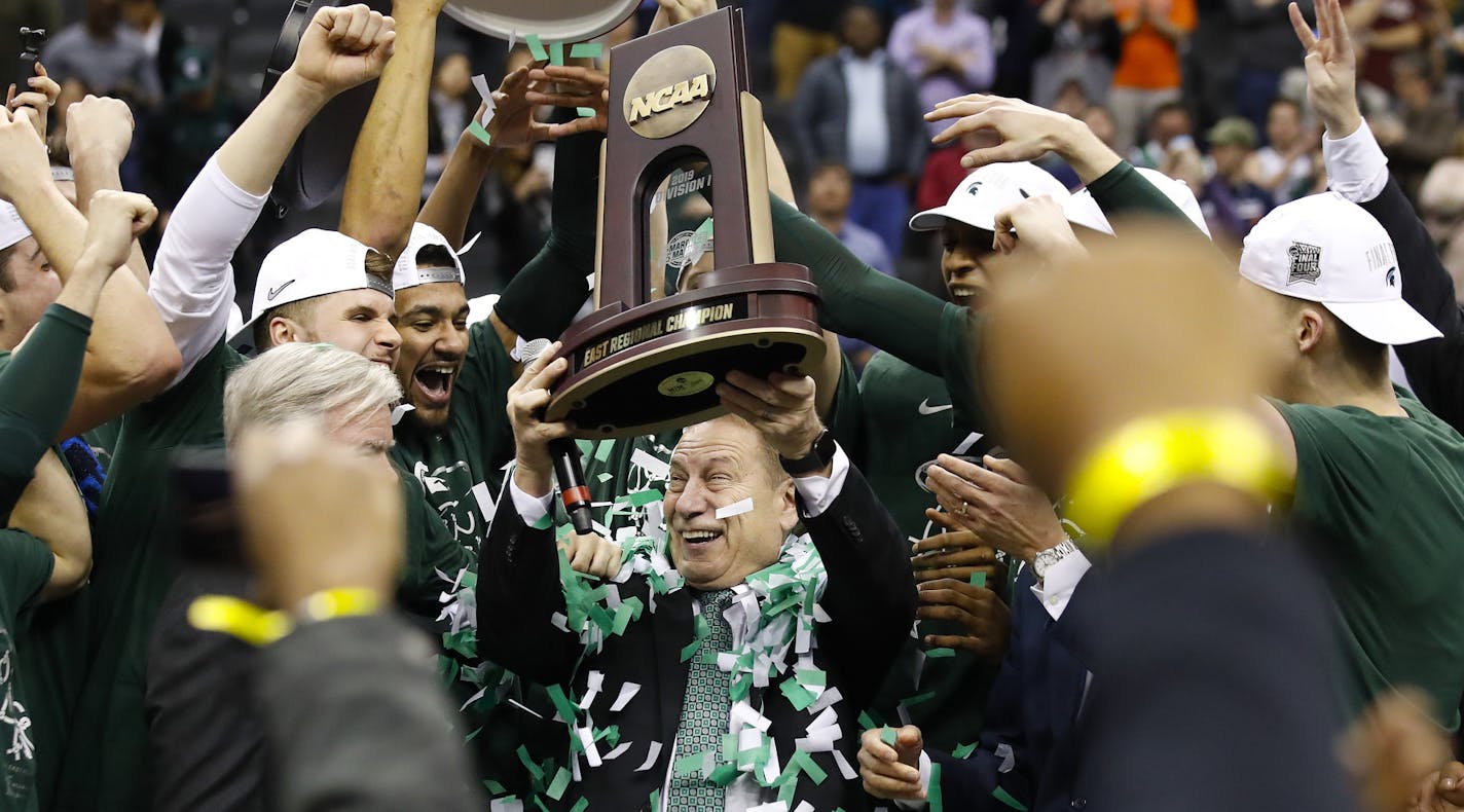 Michigan State head coach Tom Izzo holds up the NCAA men's East Regional Championship trophy after defeating Duke in a college basketball game in Washington, Sunday, March 31, 2019. Michigan State won 68-67. (AP Photo/Alex Brandon)