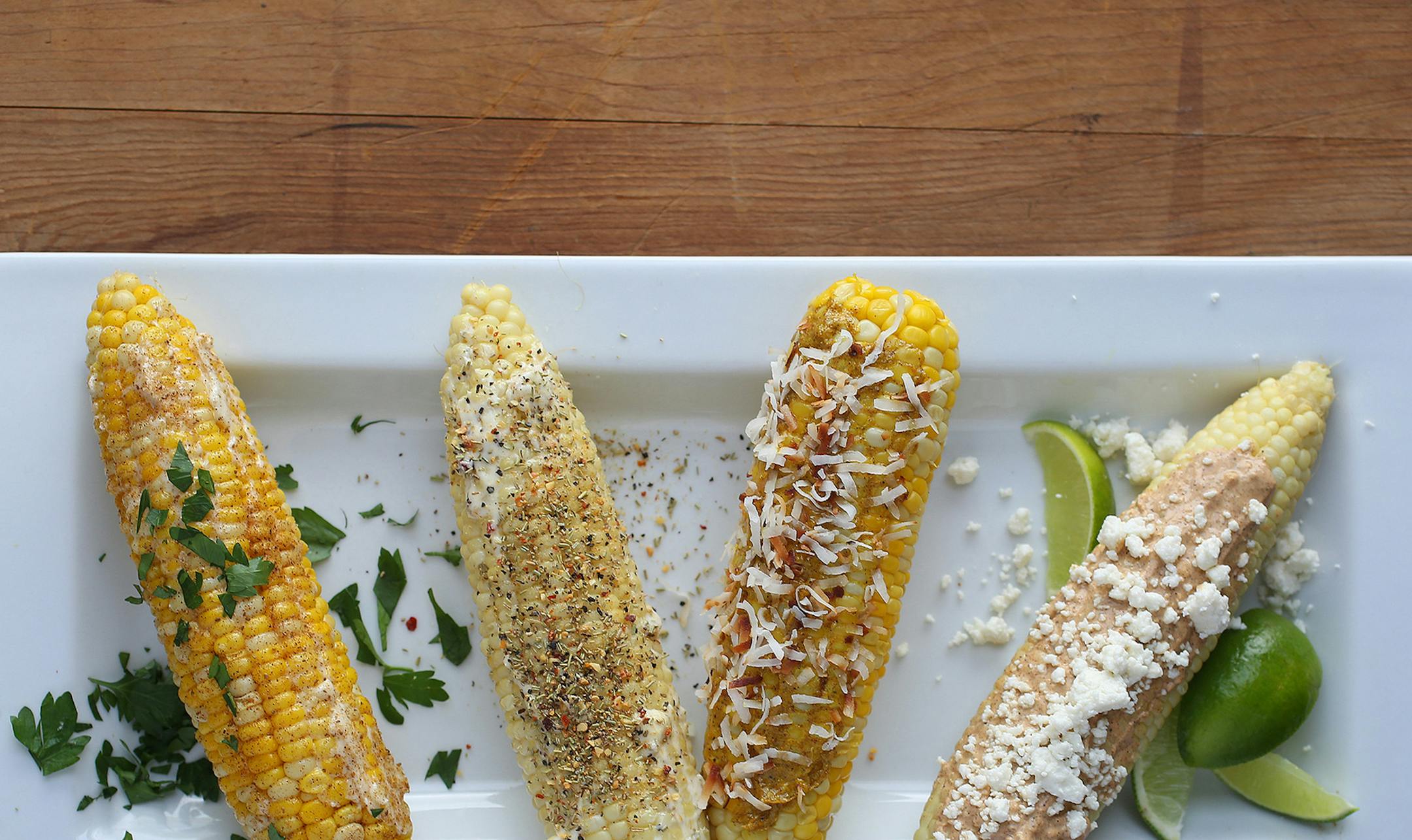 SCOTT KEELER | TAMPA BAY TIMESCorn on the cob can be topped with many different things for parties. Some examples from left to right include: garlic and Old Bay seasoning; Tuscan blend of rosemary and sun-dried tomato; Jamaican sweet corn rolled in coconut, and Oaxacan-style with queso fresco. *For release WED, July. 2, 2014* ORG XMIT: 384768