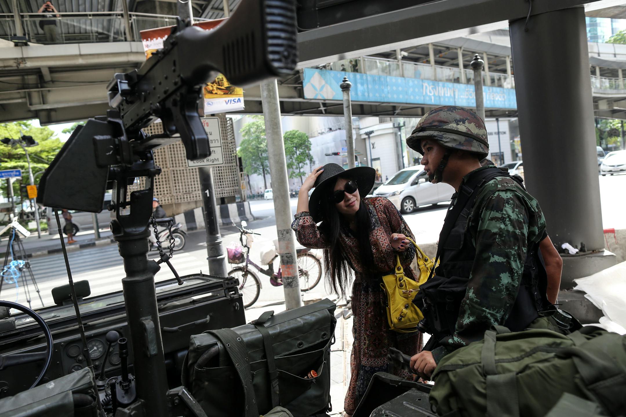 A tourist asks for directions from a Royal Thai Army soldier stationed at the Ratchaprasong intersection in central Bangkok, Thailand, on Tuesday, May 20, 2014. Thailand's army imposed martial law nationwide after months of political turmoil that brought down an elected leader and tipped the economy into a contraction. Photographer: Dario Pignatelli/Bloomberg