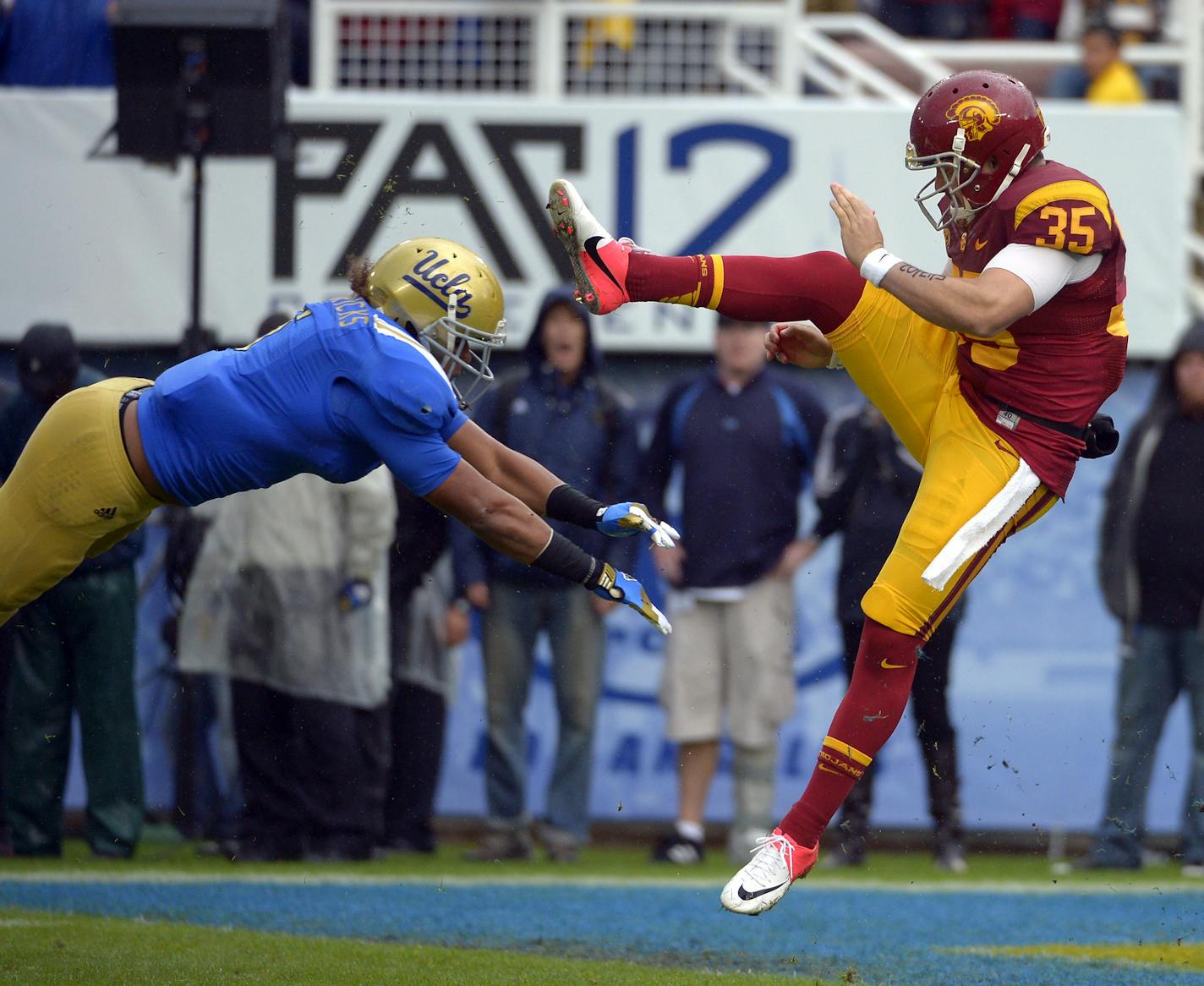 UCLA linebacker Eric Kendricks, left, blocks a punt by Southern California's Kris Albarado during the second half of their NCAA college football game, Saturday, Nov. 17, 2012, in Pasadena, Calif. UCLA won 38-28. (AP Photo/Mark J. Terrill) ORG XMIT: PRB121