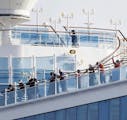 Passengers stand on the deck of the Diamond Princess cruise ship anchored at Yokohama Port in Yokohama, near Tokyo, Wednesday, Feb. 12, 2020. Japan&#x
