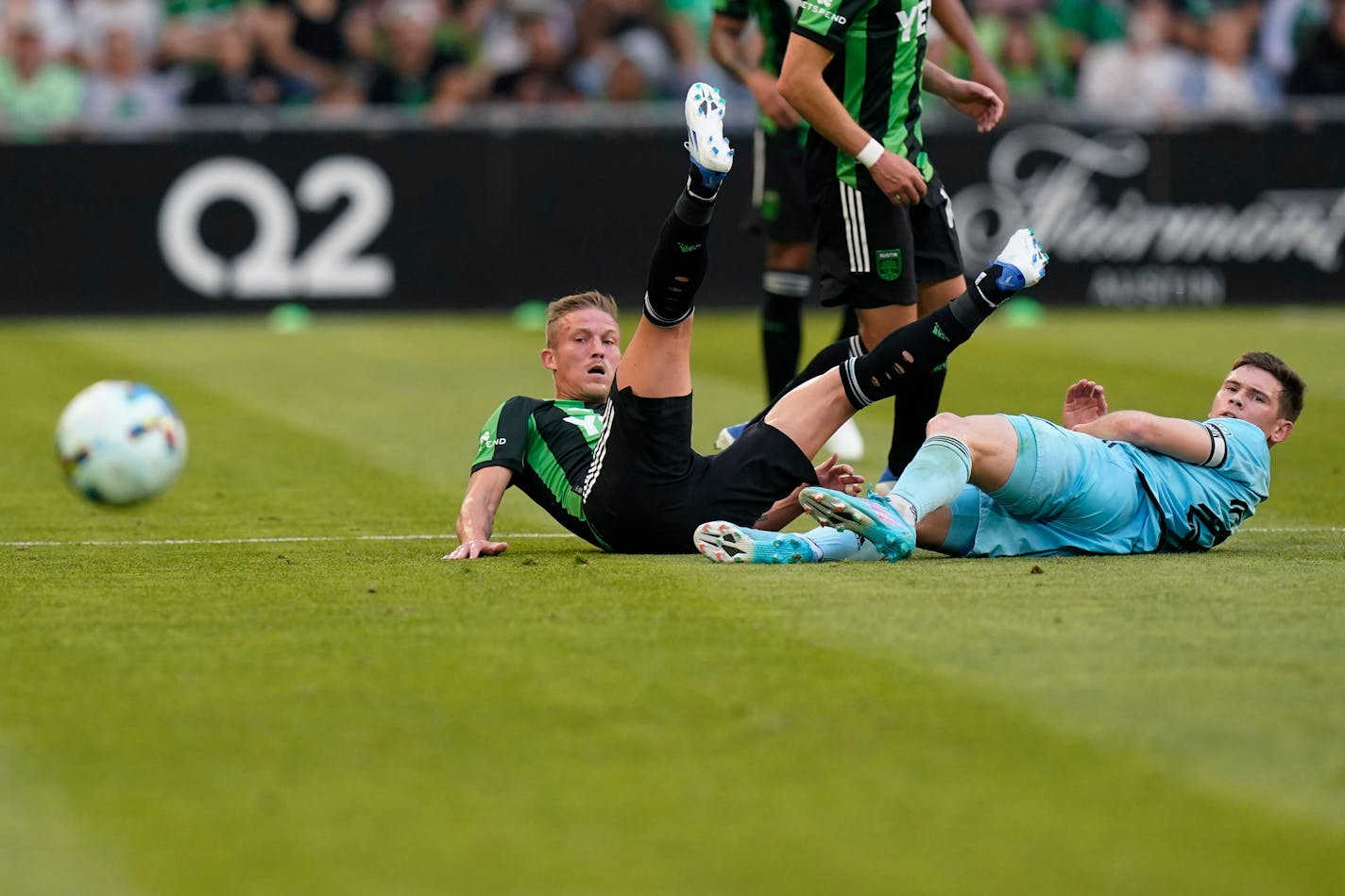 Austin FC midfielder Alex Ring, left, kicks the ball away from Minnesota United FC midfielder Wil Trapp, right, during an MLS soccer match, Sunday, April 10, 2022, in San Antonio. (AP Photo/Eric Gay)