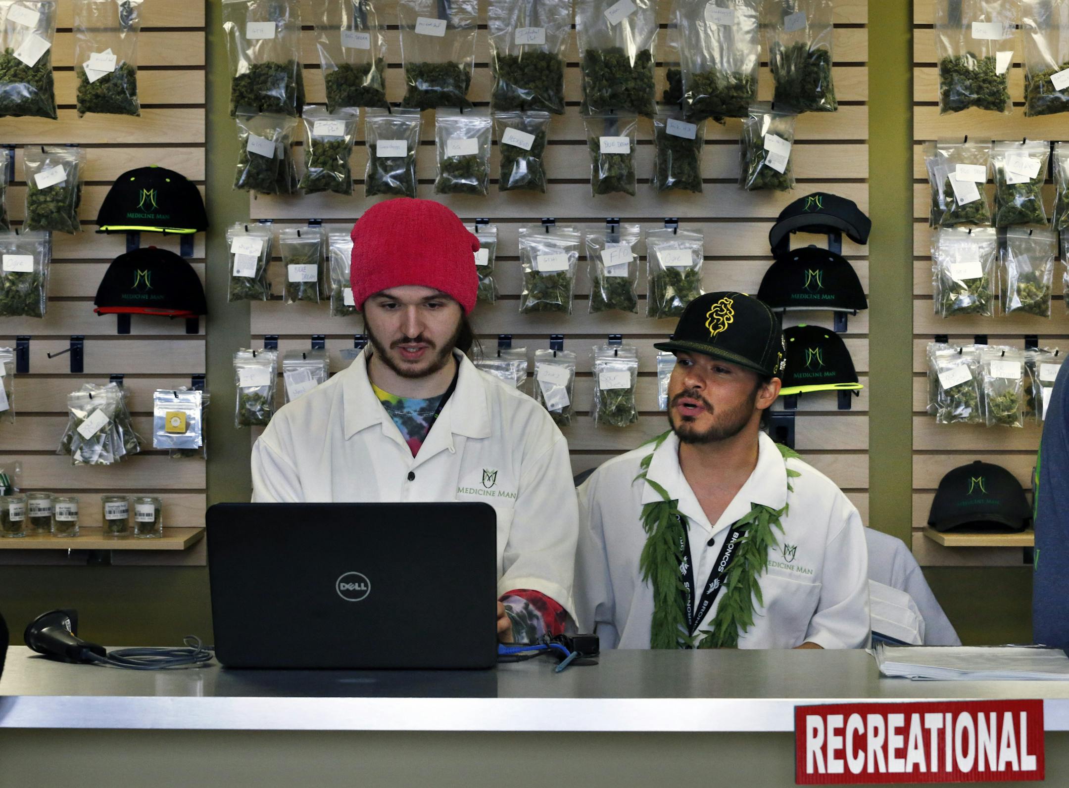 Employees David Marlow, right, and Chris Broussard work behind sales counter inside Medicine Man marijuana retail store, which opened as a legal recreational retail outlet in Denver on Wednesday Jan. 1, 2014. Colorado began retail marijuana sales on Jan. 1, a day some are calling "Green Wednesday." (AP Photo/Brennan Linsley)