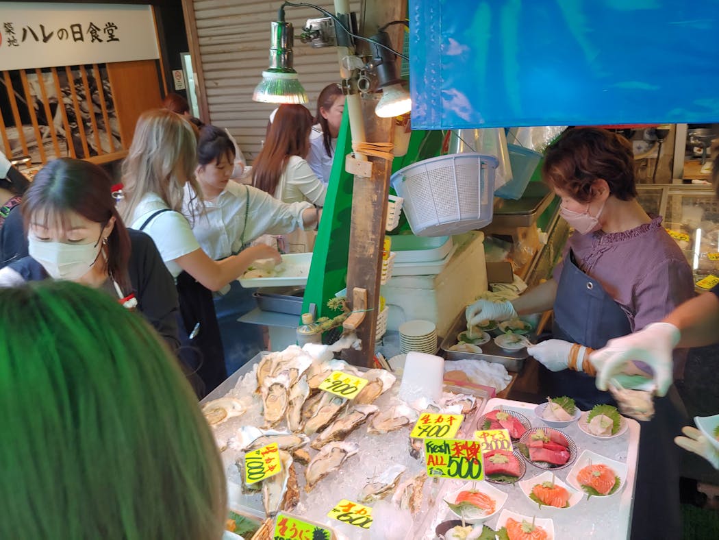 Students lined the stands at the Tsukiji fish market in Tokyo, offering a wide array of seafood.