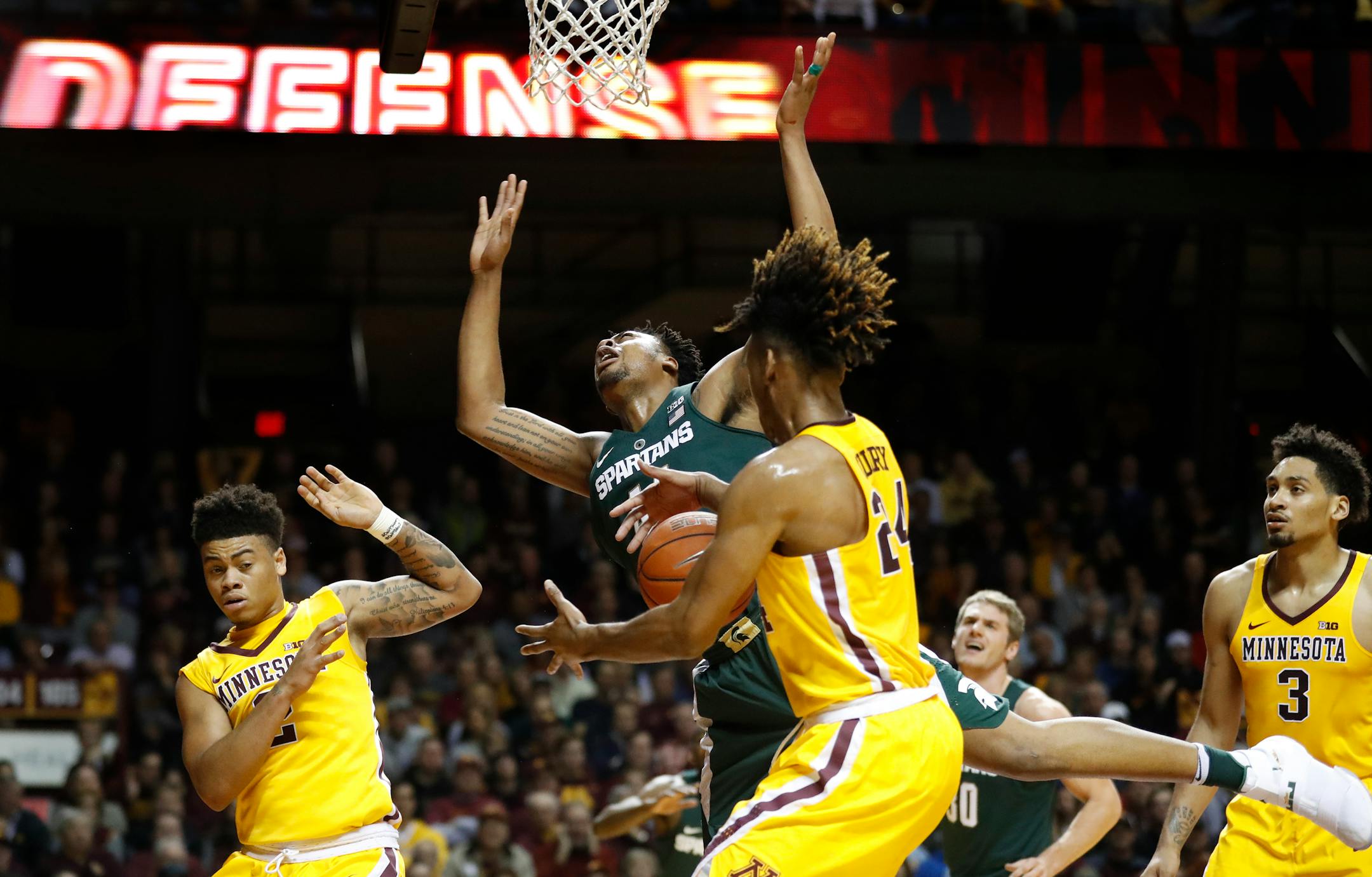 Gophers forward Eric Curry (24) fouled Spartans forward Nick Ward (44) in the first half at Williams Arena on Tuesday night.