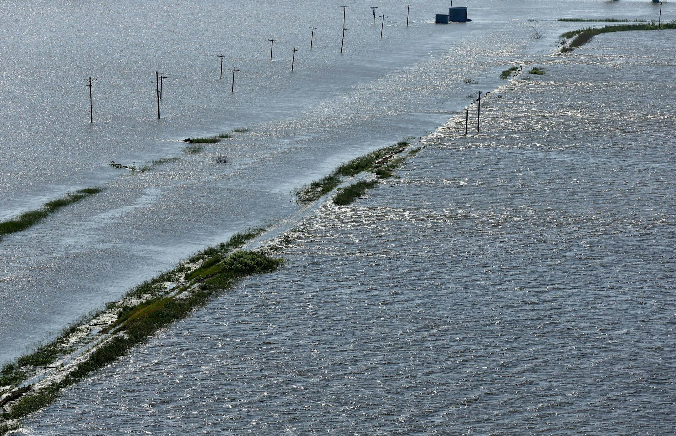 FILE - In this June 5, 2019, file photo, Mississippi River flows over the breached Pin Oak levee flooding homes and buildings in Winfield, Mo., during historic flooding on the river. With flood concerns already high in the Midwest, the U.S. Army Corps of Engineers is warning that many levees on the Missouri and Kansas rivers that were damaged during last year's devastating floods remain vulnerable to high water. (David Carson/St. Louis Post-Dispatch via AP, File)