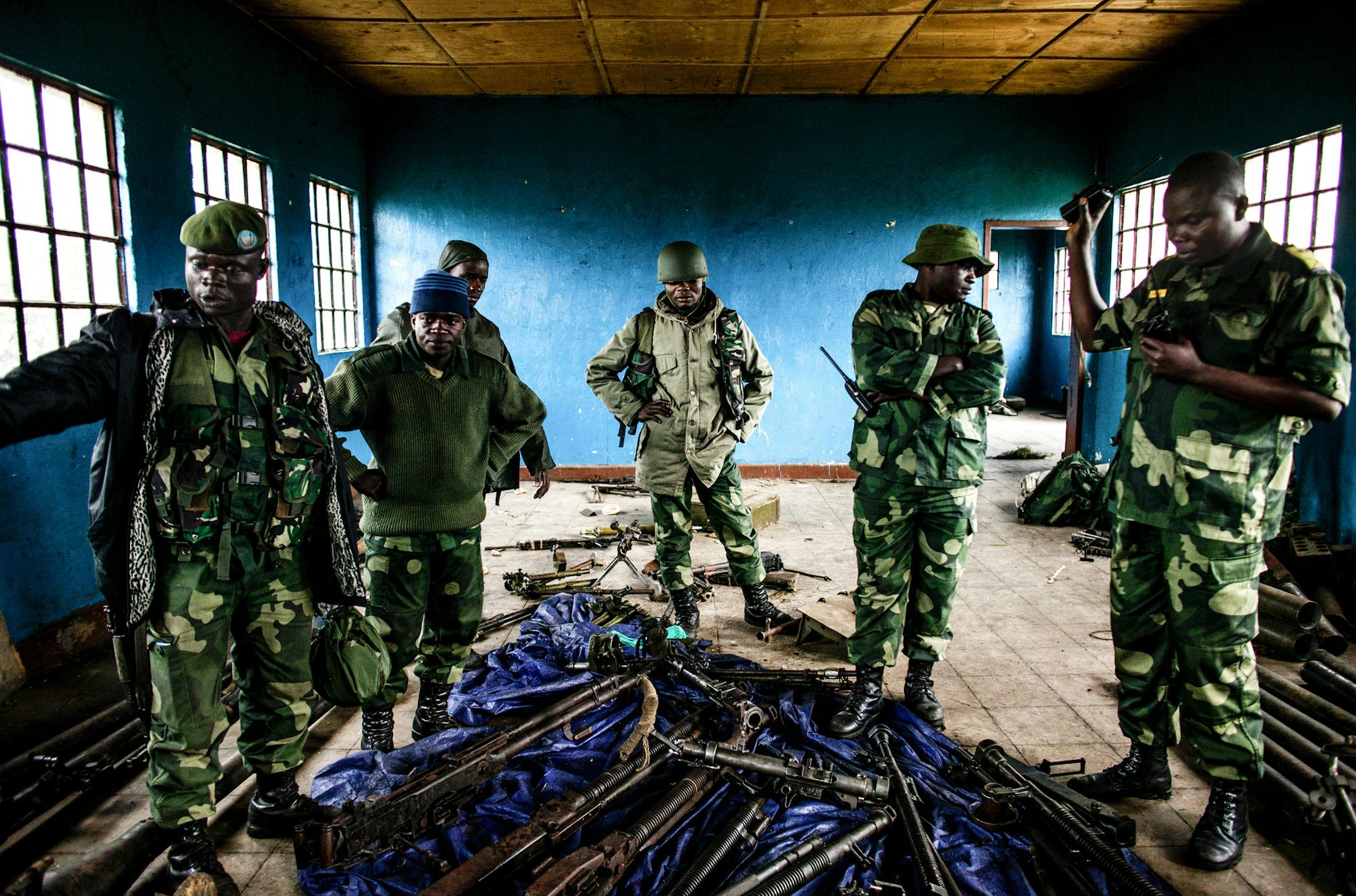 Congolese soldiers inspect munitions abandoned by rebels at a former M23 military base in Rumangabo, north of Goma, Democratic Republic of Congo, Oct. 29, 2013. A feared rebel group in the Democratic Republic of Congo announced Tuesday that it was laying down its arms immediately, in a major development that held out hope of a new era of peace and stability in the violence-wracked region. (Pete Muller/The New York Times)