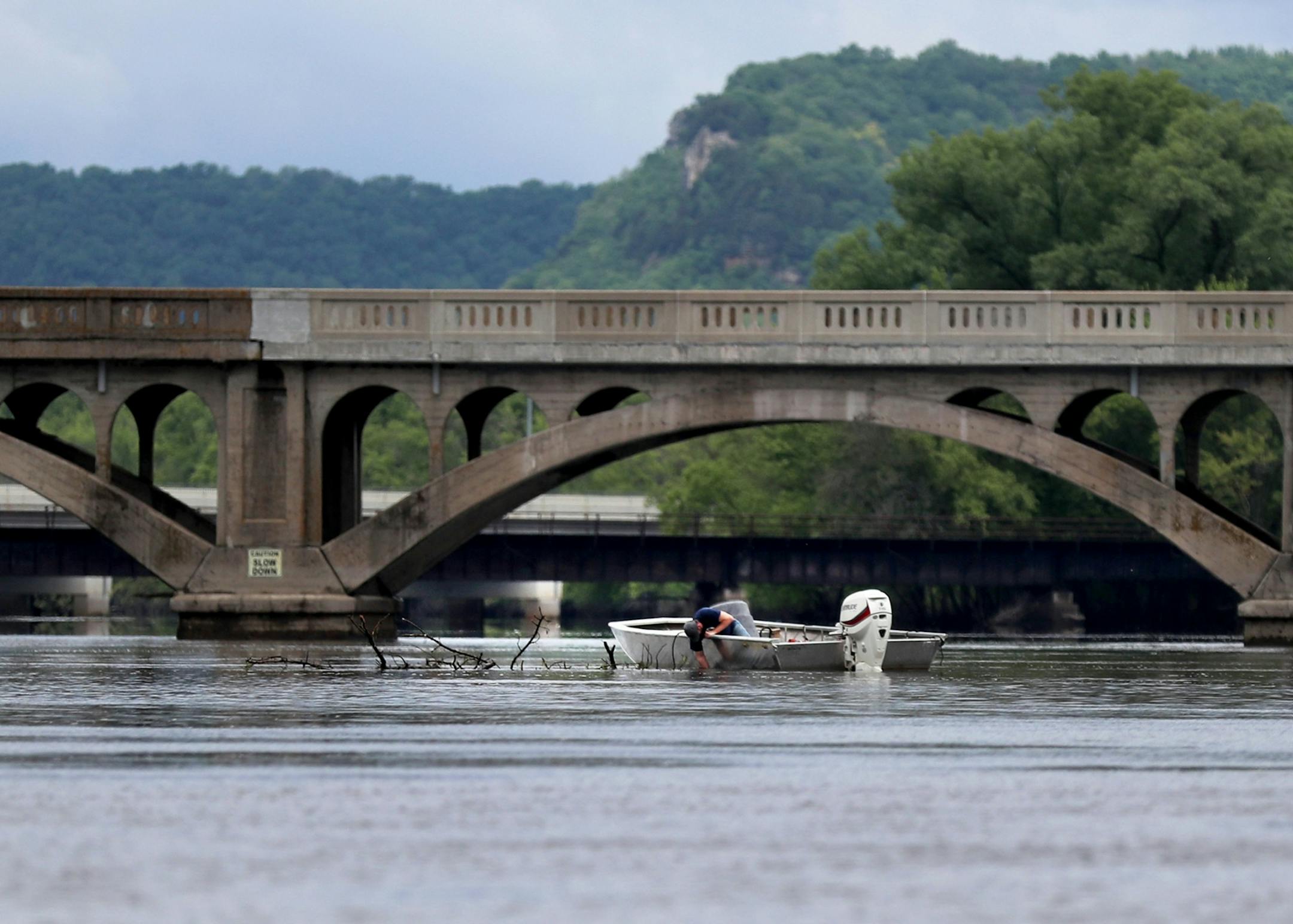 A boathouse resident dragged a large tree limb with his boat to the middle of the Mississippi River after it had been lodged near his boathouse in Winona.