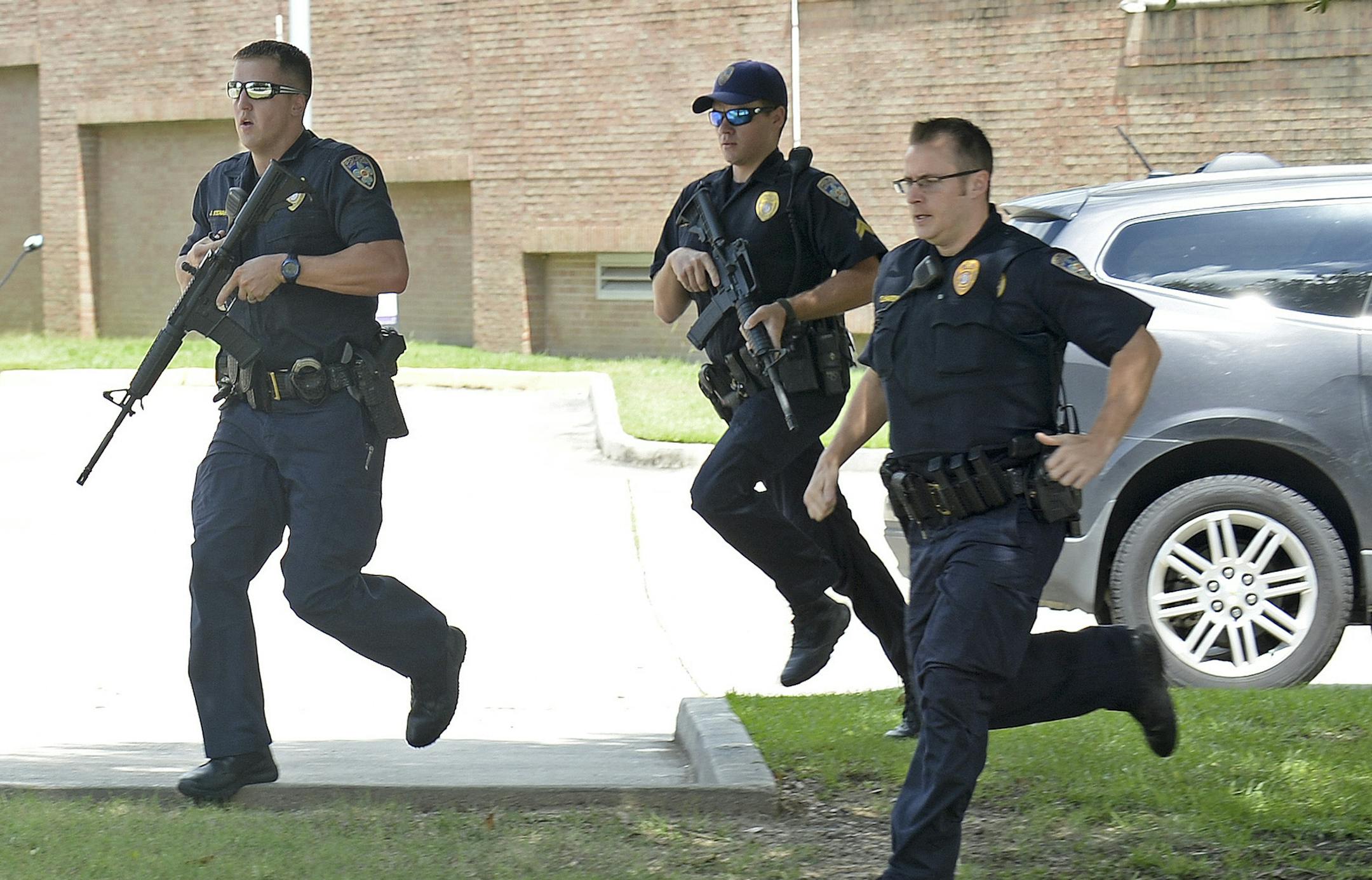 Baton Rouge Police run from the emergency room ramp as a man is taken into custody after a gun was found in his vehicle near the entrance of Our Lady Of The Lake Medical Center, Sunday, July 17, 2016, in Baton Rouge, La. Multiple law enforcement officers were killed and wounded Sunday morning in a shooting near a gas station in Baton Rouge. (Hilary Scheinuk/The Advocate via AP) ORG XMIT: MIN2016071716184935